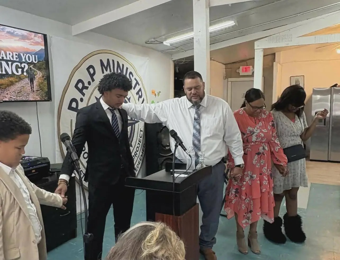 Pastor Jon Brown praying with the congregation at Prodigal Remnant Project